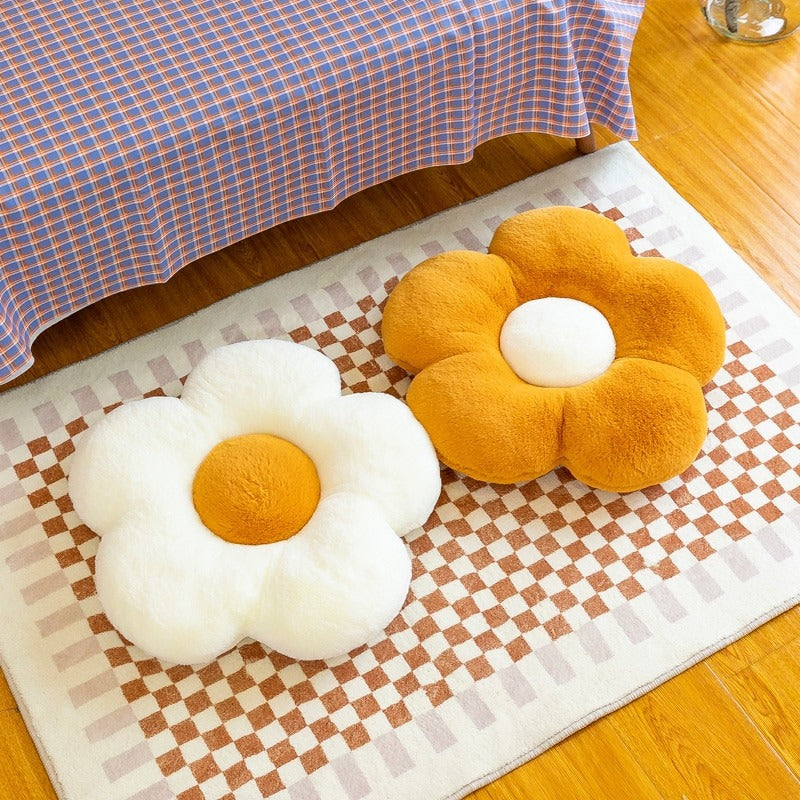 Two flower shaped pillows on a rug on the floor