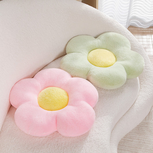 Two flower shaped pillows on a couch, green and pink color
